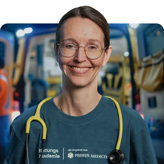Anne Hellriegel vor Rettungswagen mit Stethoskop und Primus Medicinae Shirt.