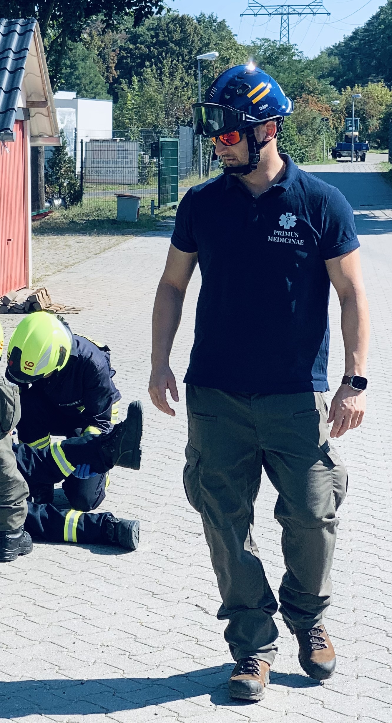 Übungsleiter Boris Schweizer mit Schutzhelm und Primus Medicinae-Shirt bei einer Draußenübung