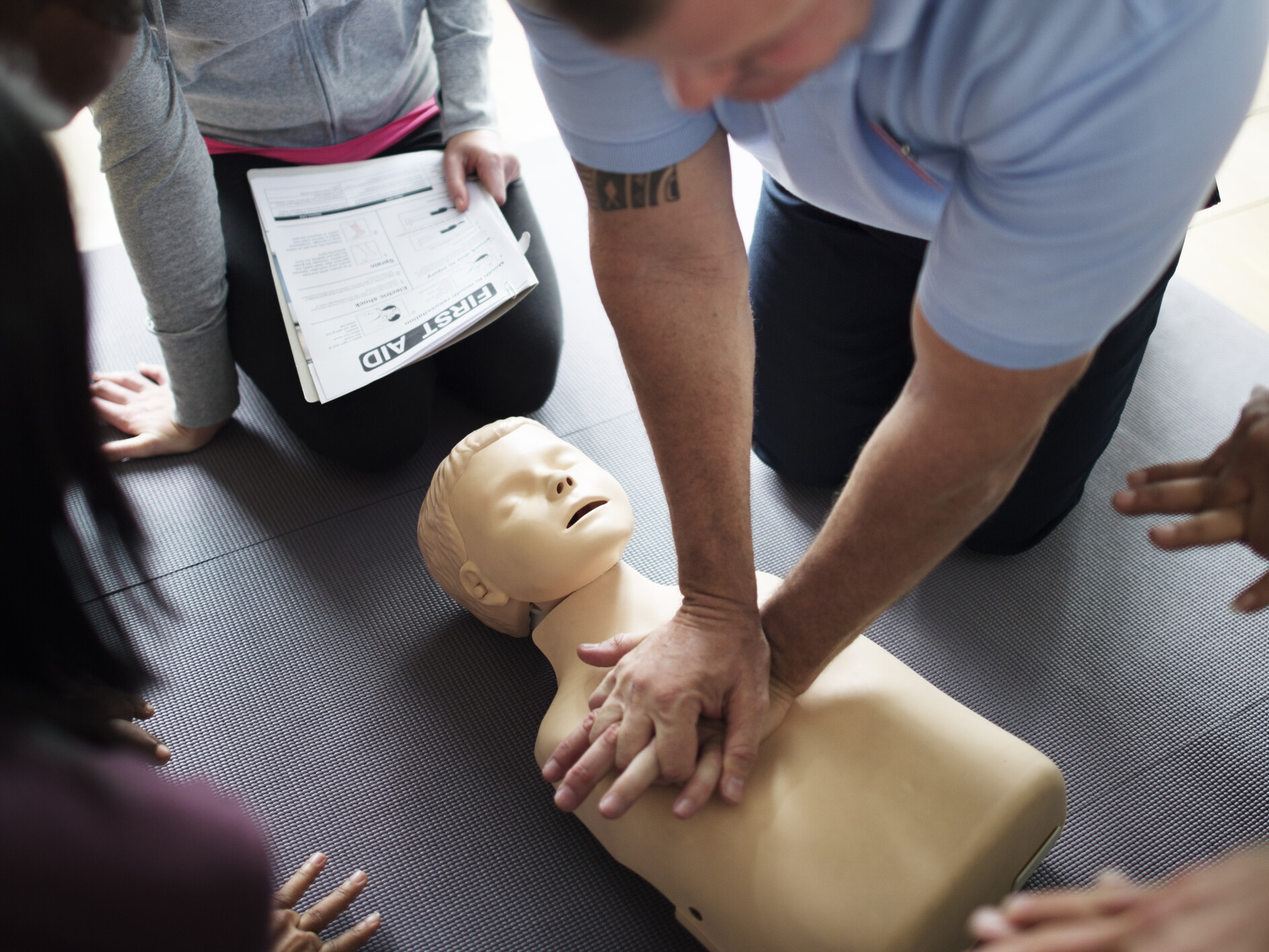 Übung Herzlungenmassage mit Dummy-Kind