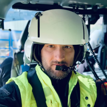 Boris Schweizer mit Helm und Funkgerät im Cockpit eines Hubschraubers